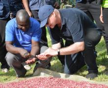 Farmer Joel Omwoi shows off his iron-rich beans to WHO director for Health Promotion, Dr Ruediger Krech