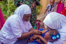 Vaccinators vaccinating a child at Bosco LGA with fIPV vaccine