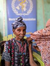 A local receives her first COVID-19 vaccine following engagement with the WHO team