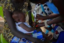 Healthcare workers administering the polio vaccine to a child as part of immunization efforts to protect children from poliovirus.