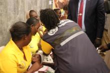 WHO staff administering the polio vaccine to a child as part of immunization efforts to protect children from poliovirus.
