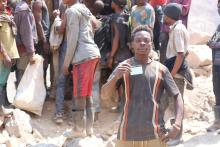 À Tilwezembe, Samy Maloba, creuseur artisanal, lève fièrement sa carte de vaccination, symbole d’espoir et de protection, après avoir reçu sa dose du vaccin antiamaril (VAA). Un geste simple, mais essentiel pour préserver la santé et bâtir un avenir plus sûr. OMS/Vivian Nzabarinda.