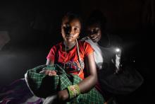 Neshoo Leaungokiok and her newborn baby, sits with Lucy Makena, a reproductive health officer from a nearby mobile outreach clinic supported by WHO.  ©WHO / Genna Print