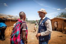 John Kismir from WHO Kenya talks to a mother during the health outreach. ©WHO / Genna Print