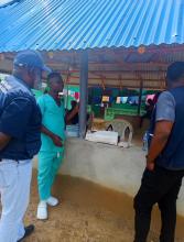 WHO Representative Dr Olushayo Olu engages with a frontline health worker during a field visit to assess yellow fever vaccination activities in Grand Cape Mount County, Liberia.