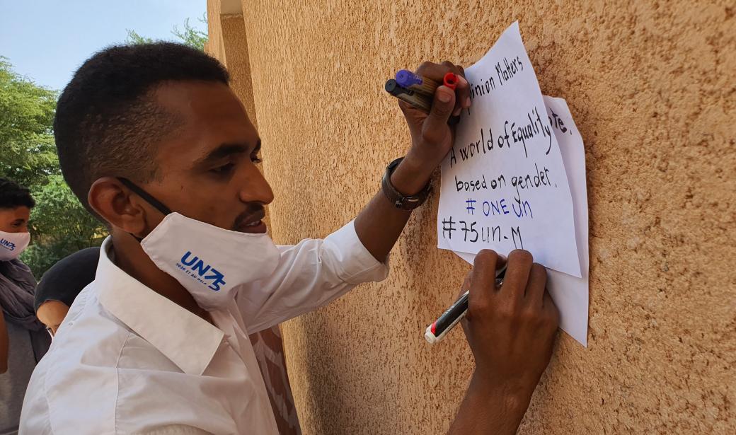 Un étudiant réfugié malien exprimant son opinion sur une pancarte