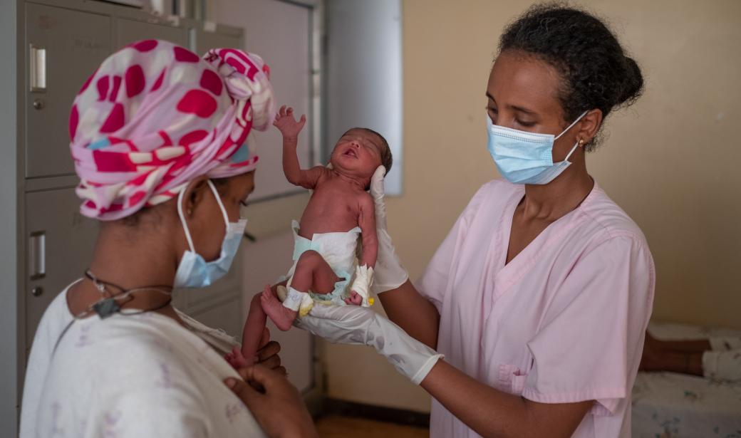 Nurse Yewognesh Gebre-Meskel (R) assists Elisabeth Ali (L) to provide skin-to-skin contact to her baby at the kangaroo mother care unit at Felege Hiwot Hospital. 