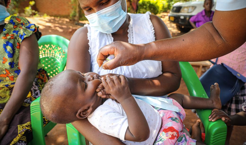 Odala Phiri holds her daughter Happiness Mark as the vaccinator administers the polio vaccine
