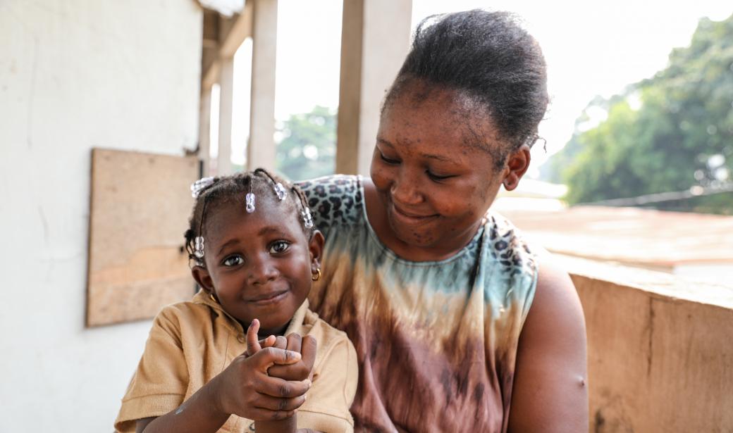 Cecile shows her finger following immunization. She is now protected against polio.
