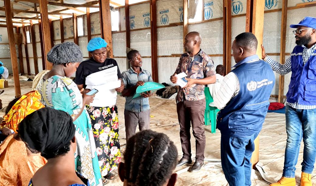 Le médecin chef de zone de Kalemie, les experts de l'OMS et de l'OIM échangeant avec l'équipe de vaccination du site de déplacés de Likasi, au sud-ouest de Kalemie