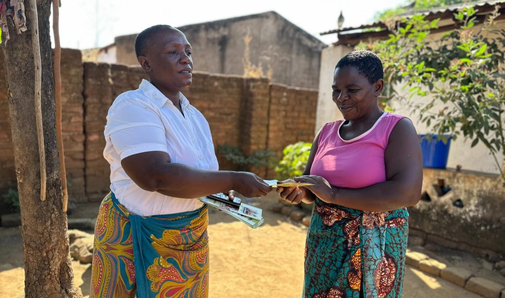 Community volunteer distributing cholera IEC materials 