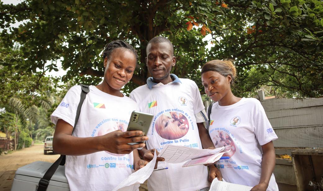 WHO-trained vaccinator Sandrine Lina, shows her device to the rest of her team as the tracker is active.