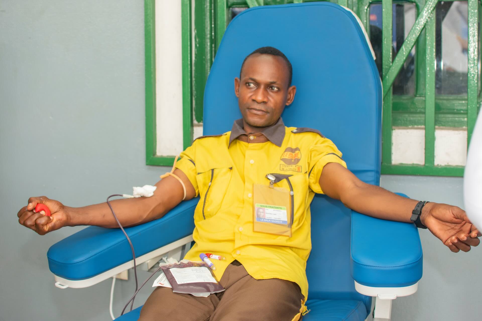 A young donor relaxes in a blue donation chair during a blood drive
